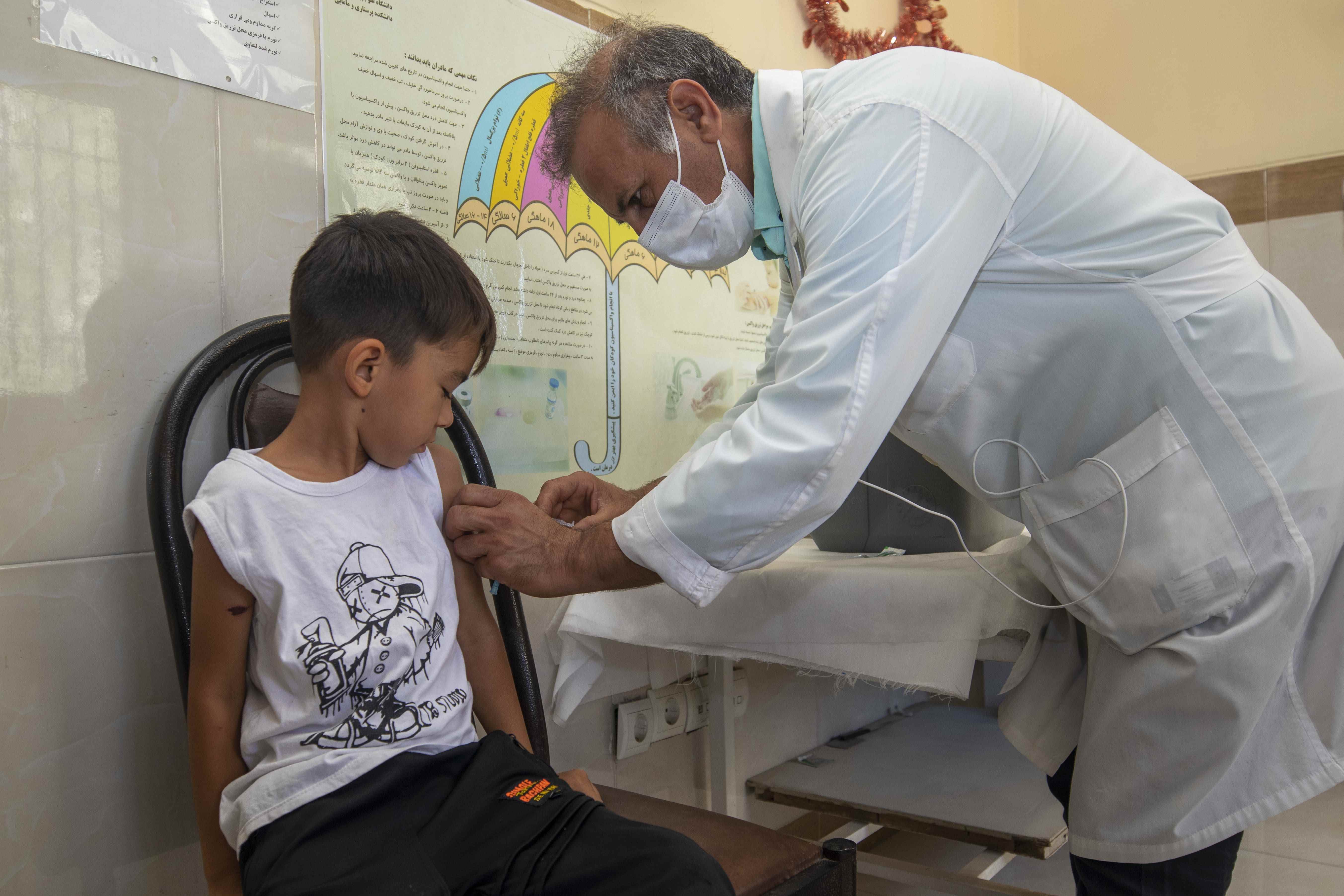 An Afghan refugee child iat a health centre, south of Tehran, receiving vaccination.