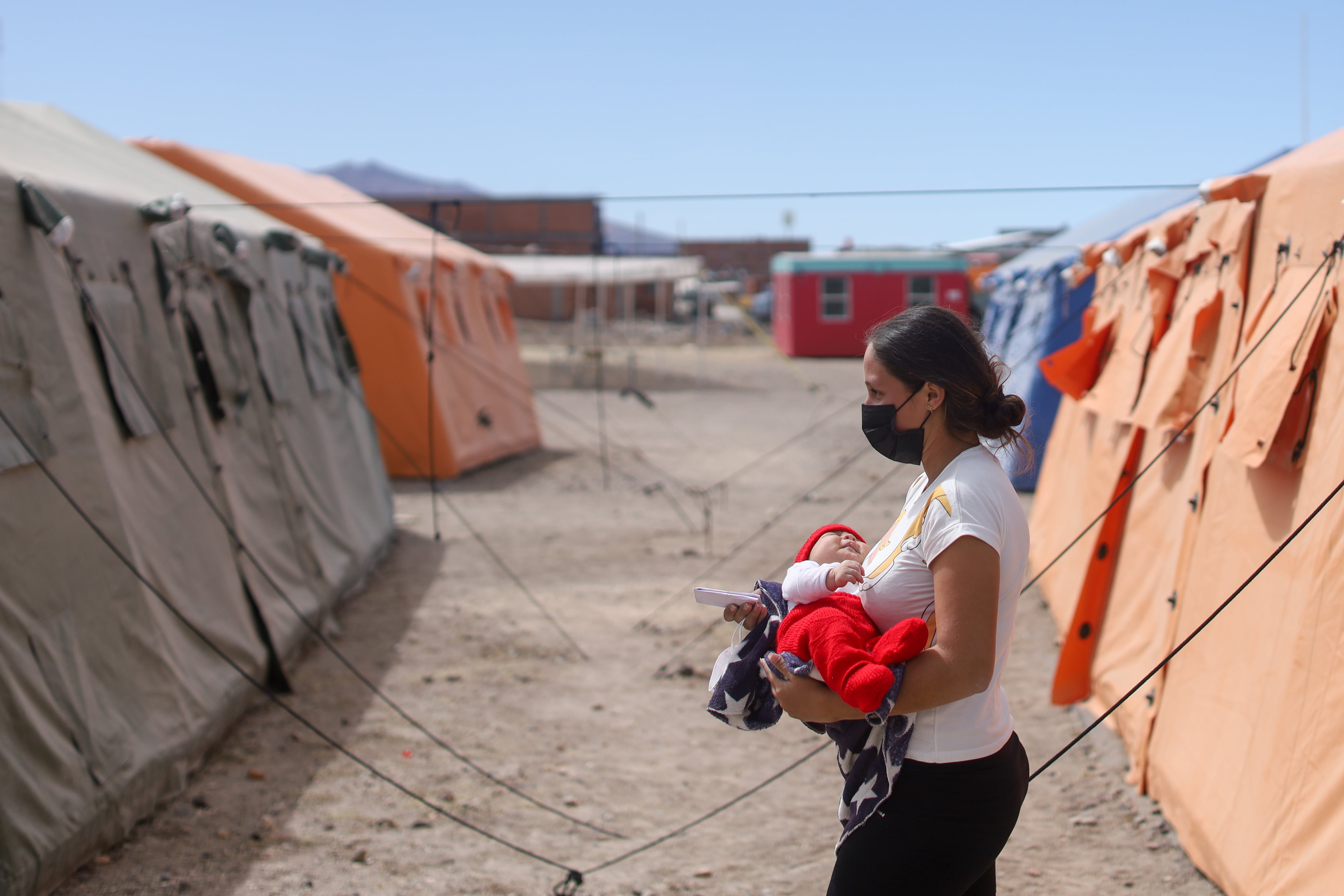 Andrelis Alvarez (21 years old) walks with his son Damian (1 month and a half) in the UNICEF-supported reception center for migrant families located in Colchane, Chile on April 27, 2022.